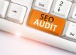 Writing note showing Seo Audit. Business concept for Search Engine Optimization validating and verifying process White pc keyboard with note paper above the white background
