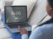 African American blogger posting online via laptop on sofa at home, collage